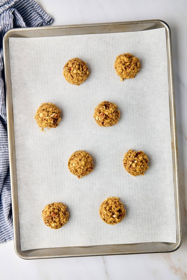overhead view of brown butter maple oatmeal cookie dough portioned onto a parchment-lined baking sheet