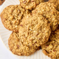 brown butter maple oatmeal cookies in a pile on a white plate