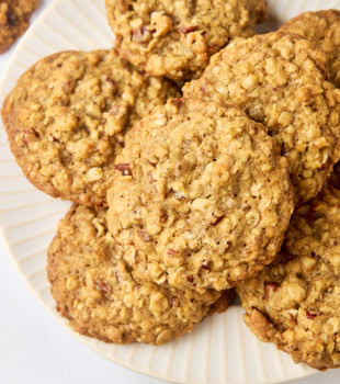 brown butter maple oatmeal cookies in a pile on a white plate