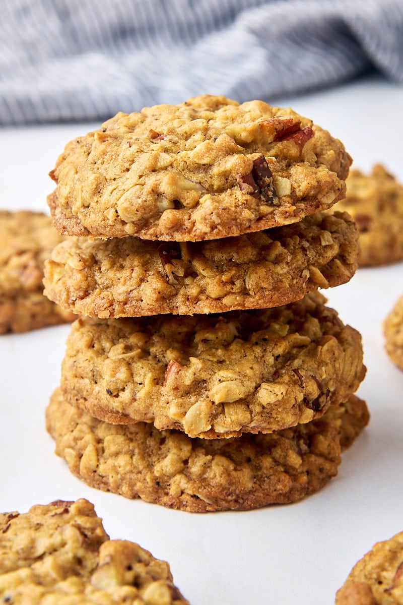 stack of four brown butter maple oatmeal cookies surrounded by more cookies