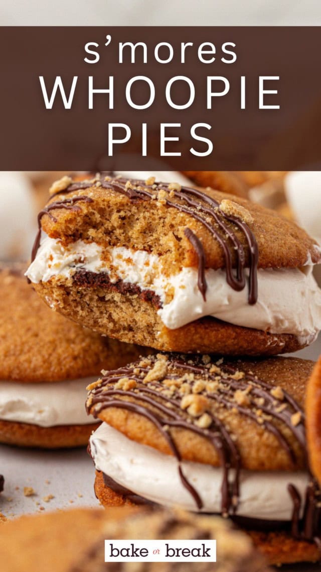 a s'mores whoopie pie with a bite missing sitting on top of more whoopie pies
