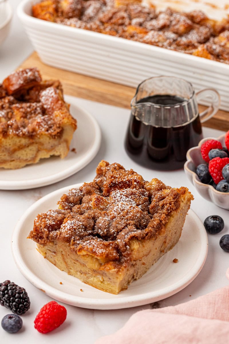 a serving of baked French toast on a white plate with more French toast in the background