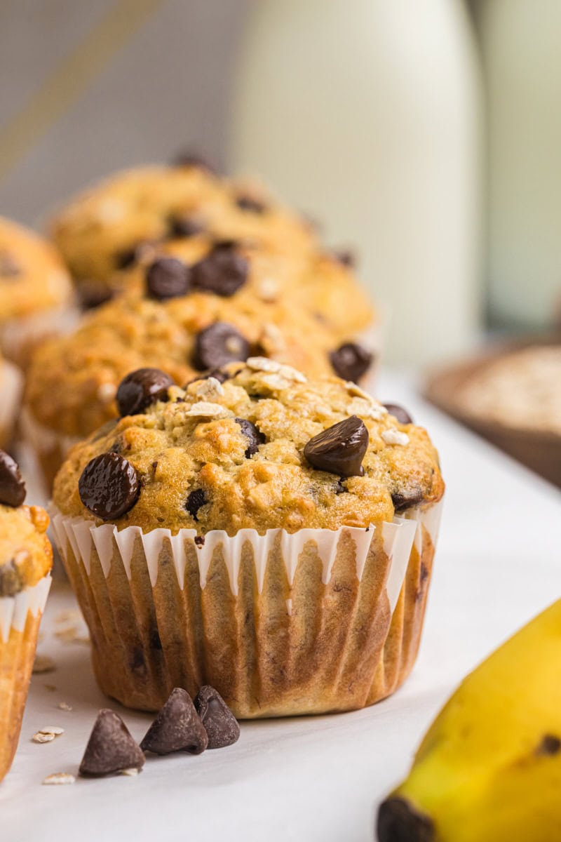 close-up of a banana oatmeal chocolate chip muffin with more muffins in the background