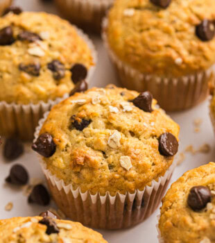 banana oatmeal chocolate chip muffins on a white surface