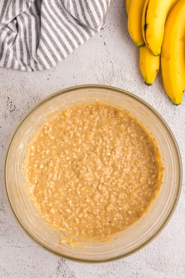overhead view of banana muffin batter in a glass mixing bowl