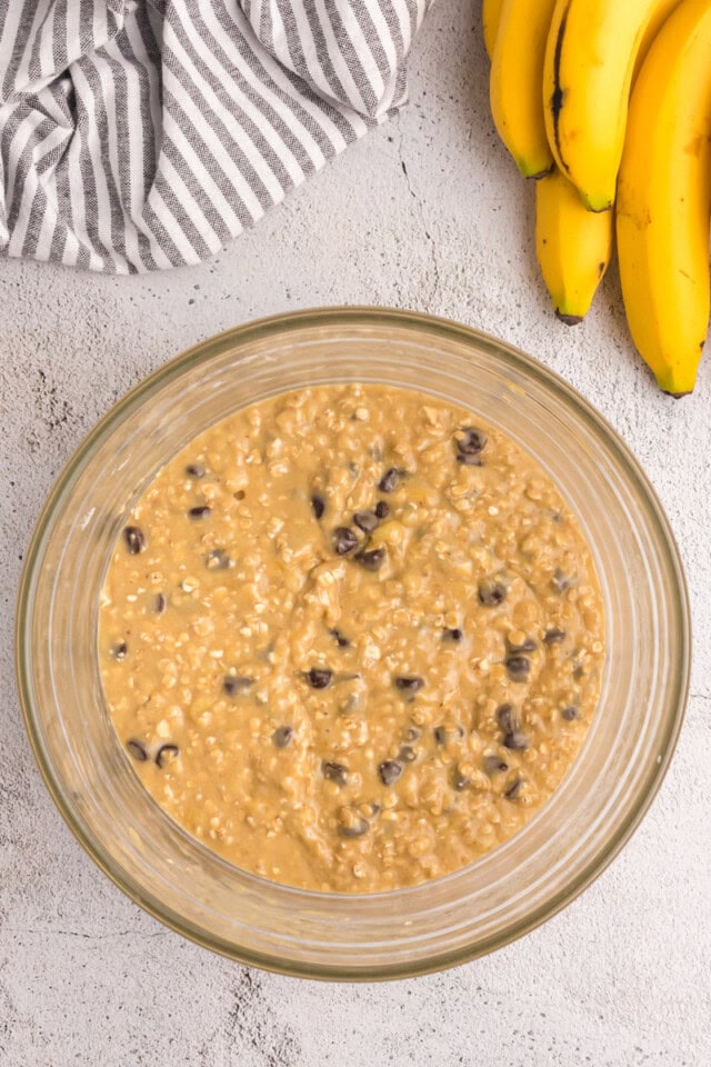 overhead view of banana oatmeal chocolate chip muffin batter in a glass mixing bowl