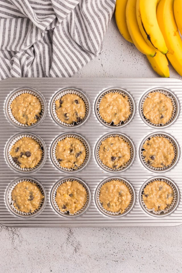 overhead view of banana oatmeal chocolate chip muffins in a muffin pan ready to go into the oven