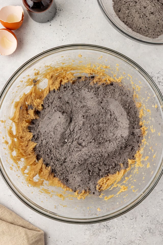 overhead view of dry ingredients added to wet ingredients for black cocoa cookies