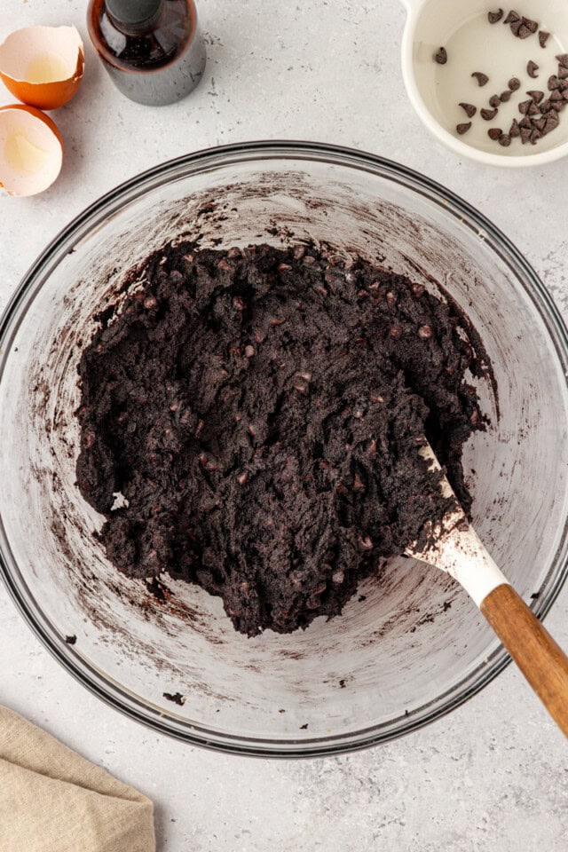 overhead view of black cocoa cookie dough in a glass mixing bowl