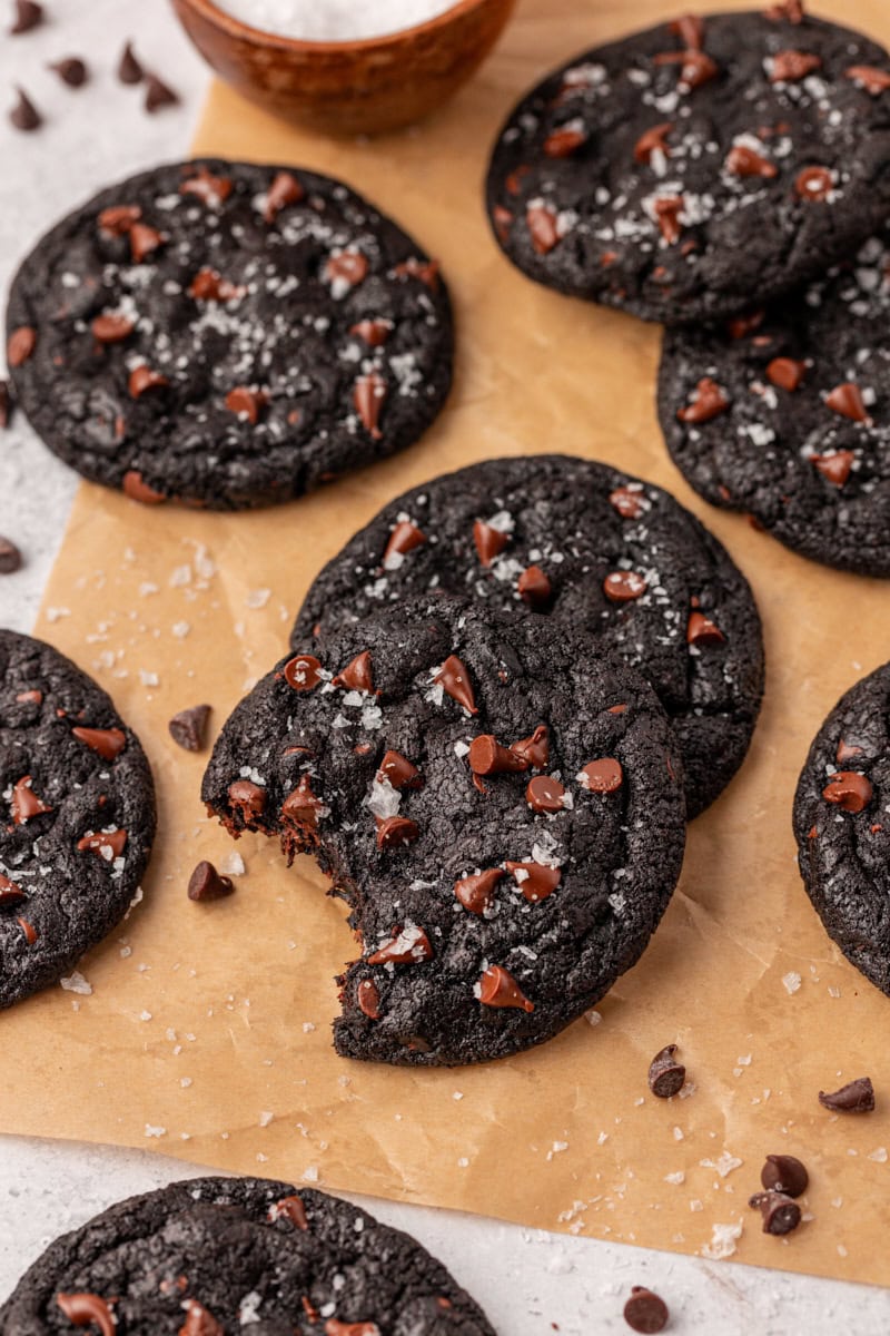 black cocoa cookies scattered over parchment paper on a white surface