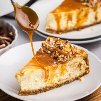 caramel drizzling over a slice of bourbon caramel swirl cheesecake