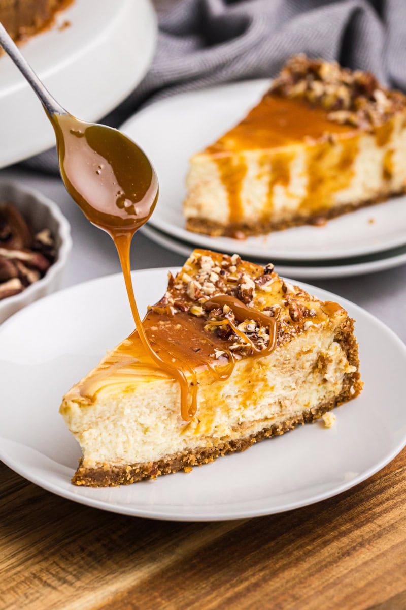 caramel drizzling over a slice of bourbon caramel swirl cheesecake