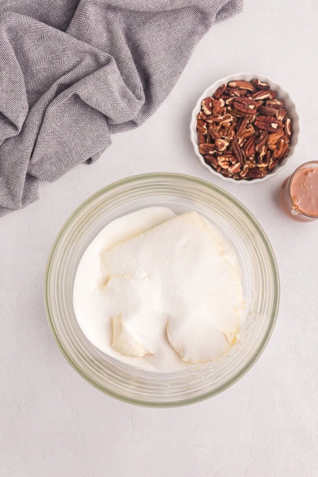 overhead view of cream cheese and sugar in a glass mixing bowl