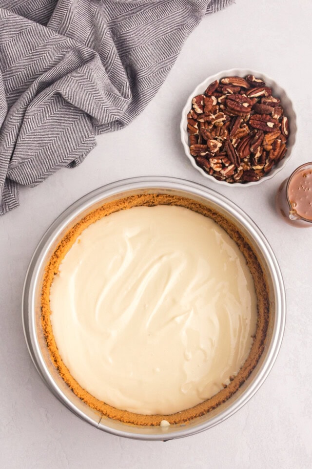 overhead view of bourbon cheesecake filling added to partially baked graham cracker crust in a springform pan