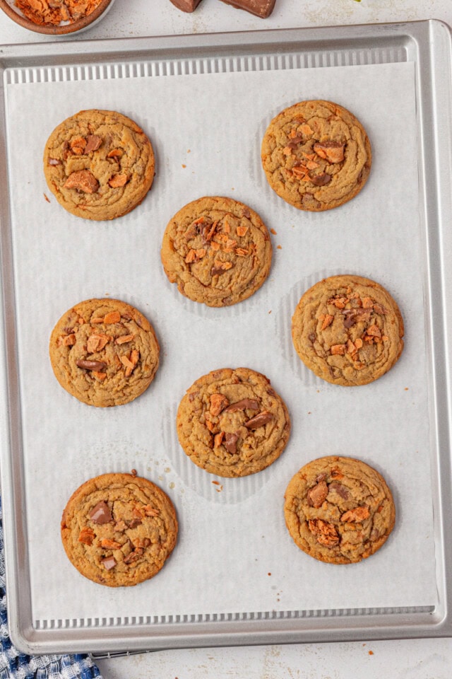 overhead view of freshly baked Butterfinger cookies on a parchment-lined baking sheet