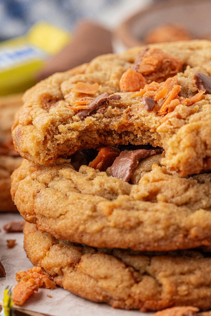 close up view of a stack of three Butterfinger cookies with a bite missing from the top cookie
