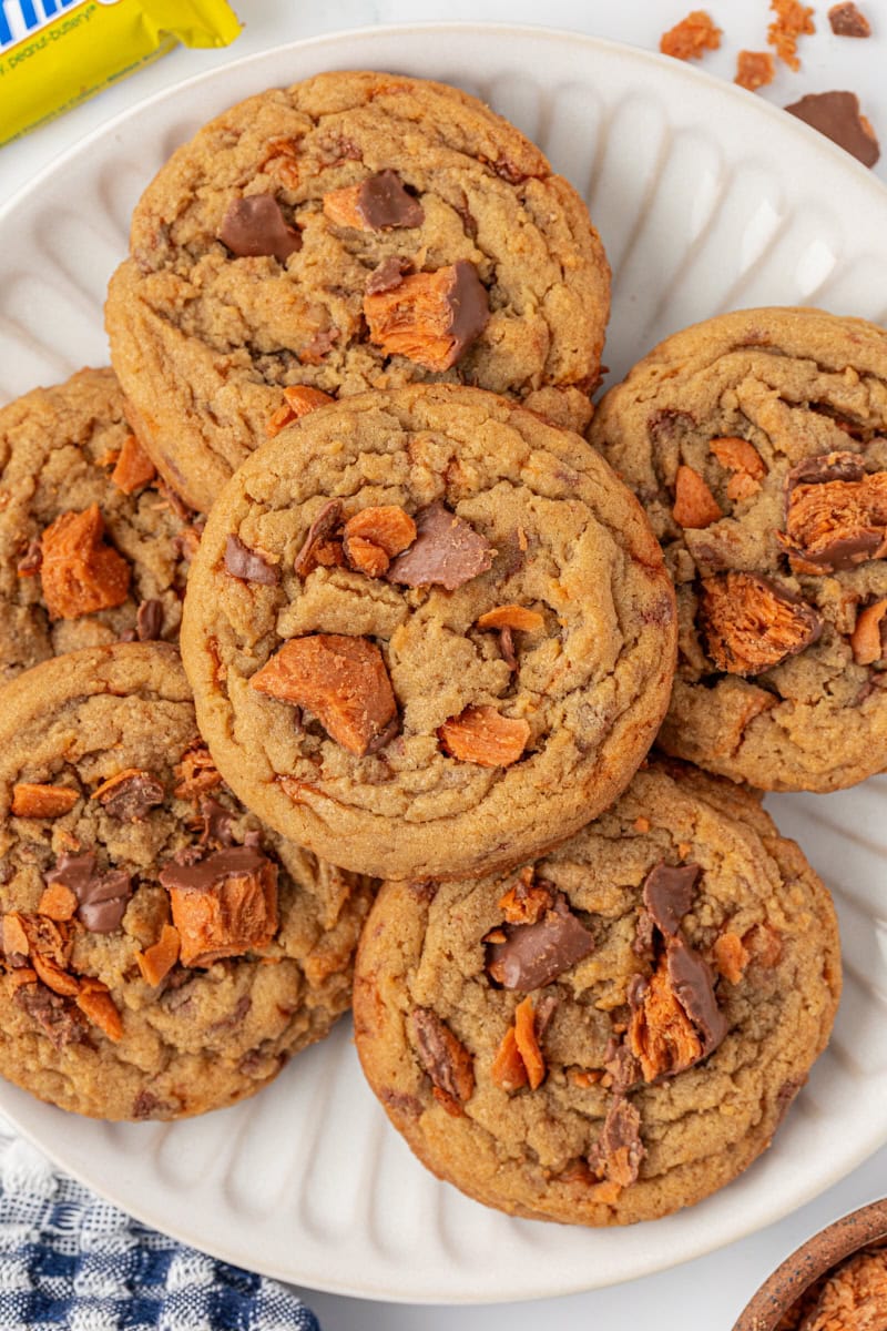 overhead view of Butterfinger cookies in a stacked pile on a white plate
