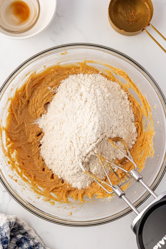 overhead view of dry ingredients added to wet ingredients for peanut butter cookies 