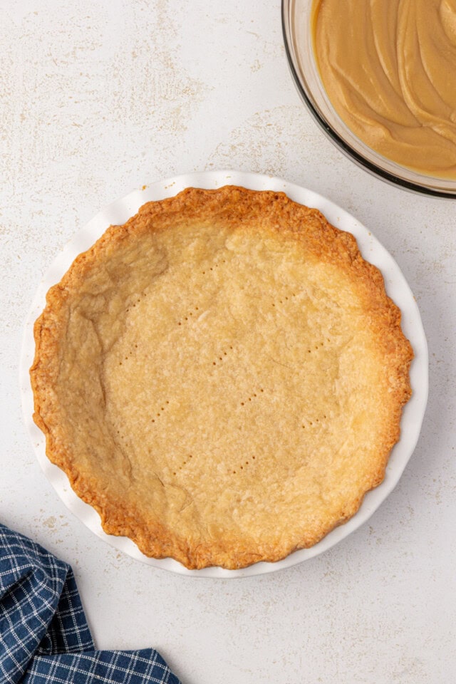 overhead view of a baked pie crust in a white pie plate