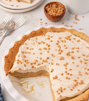 partially sliced butterscotch pie in a white pie plate