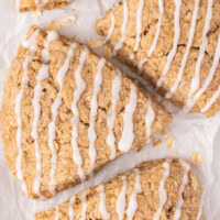 overhead view of three cinnamon oat scones on a white surface