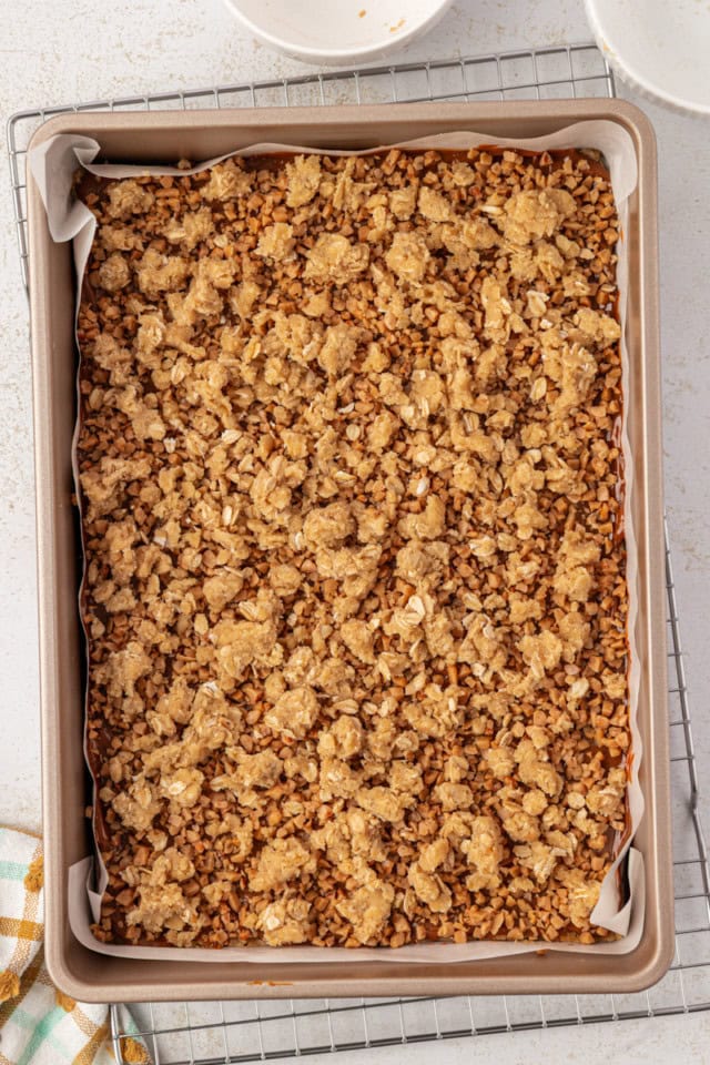 overhead view of crumb topping sprinkled over dulce de leche bars ready to go into the oven