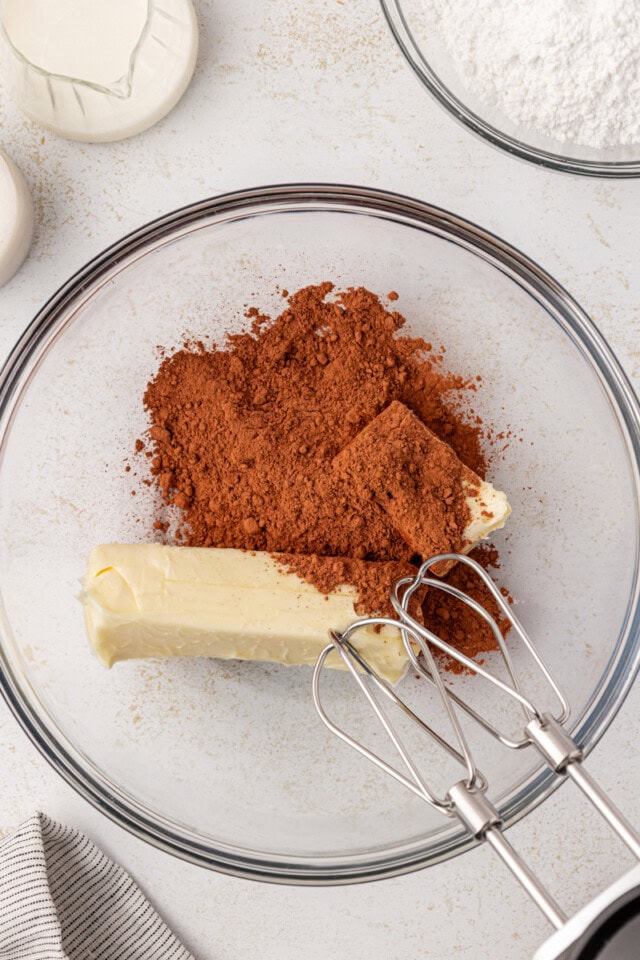 overhead view of butter and cocoa powder in a glass mixing bowl