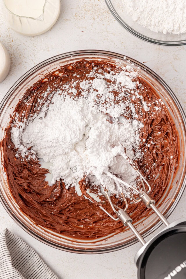 overhead view of confectioners' sugar added to beaten butter and cocoa powder