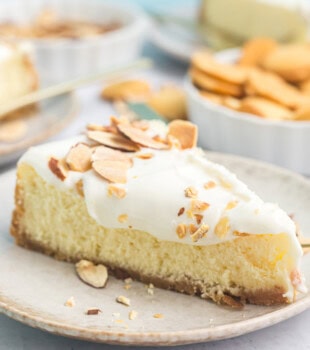 a slice of amaretto cheesecake on a plate with more cheesecake in the background