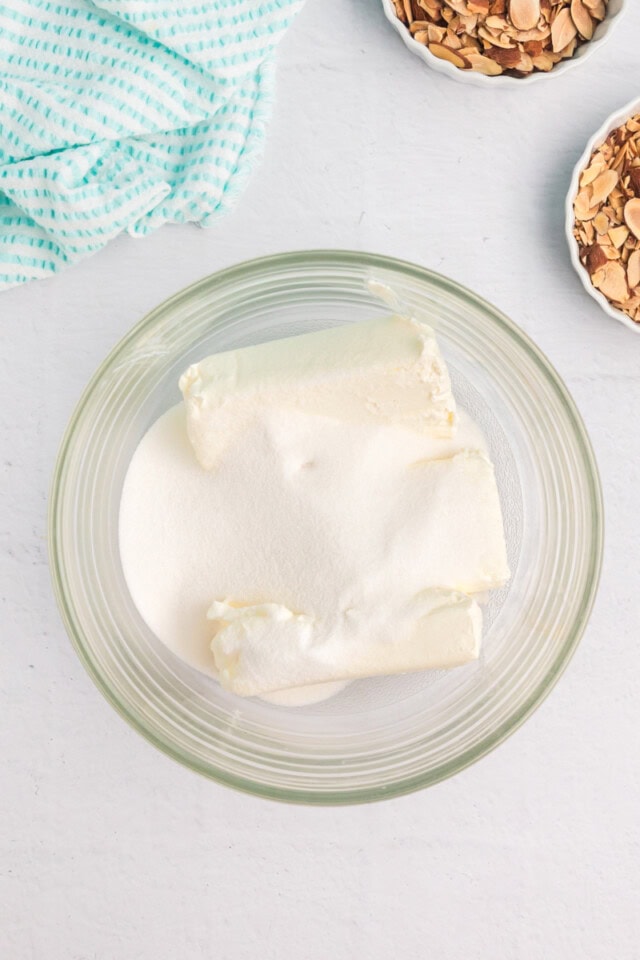 overhead view of cream cheese and sugar in a glass mixing bowl