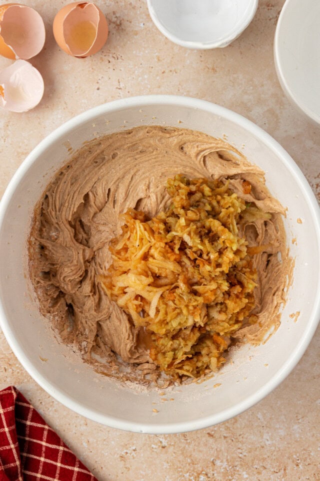 overhead view of grated apples added to cupcake batter