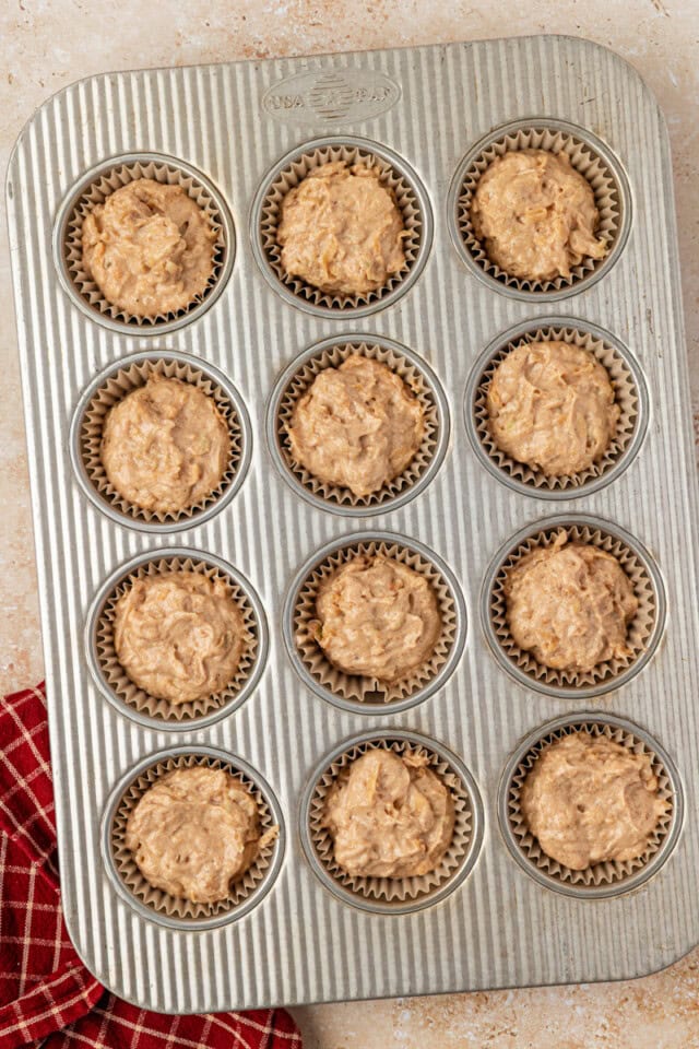 overhead view of apple cupcakes portioned into a muffin pan ready to go into the oven