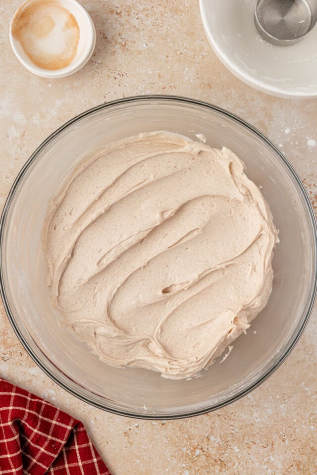 overhead view of spiced cream cheese frosting in a glass mixing bowl