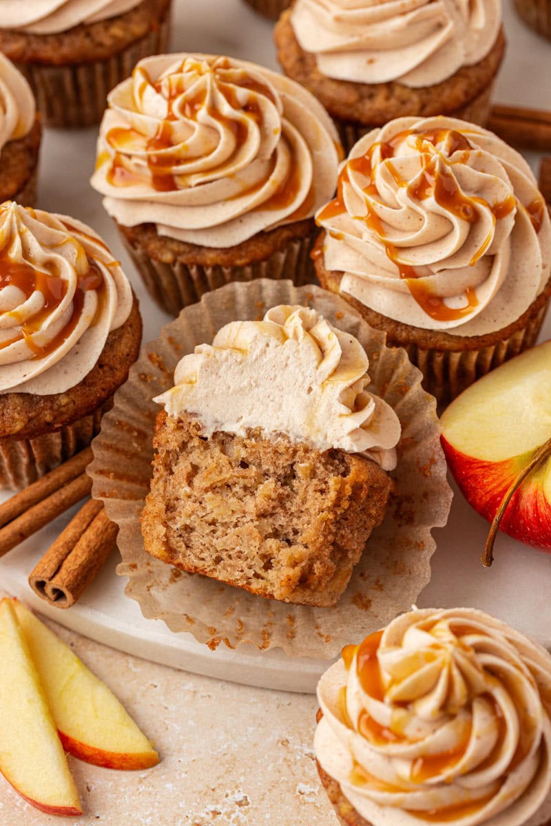 an apple cupcake cut in half surrounded by more cupcakes