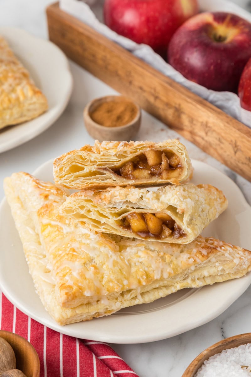 an apple turnover cut in half resting on top of another pastry