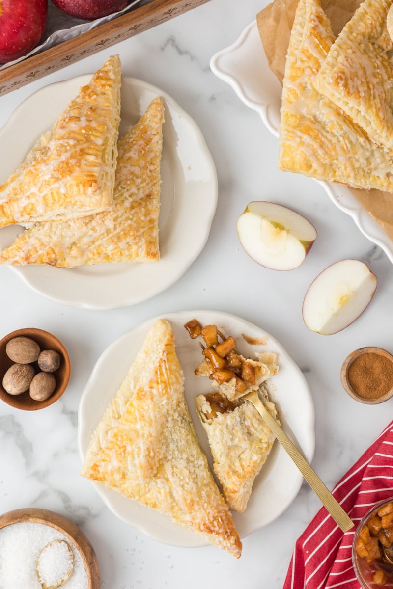 overhead view of apple turnovers served on white plates