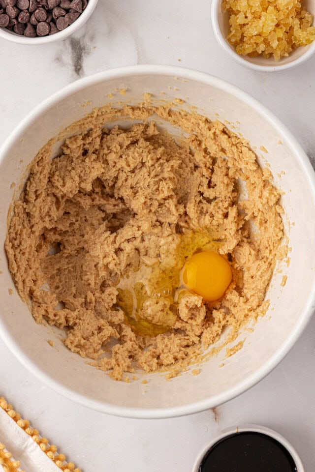 overhead view of egg added to creamed butter and sugar