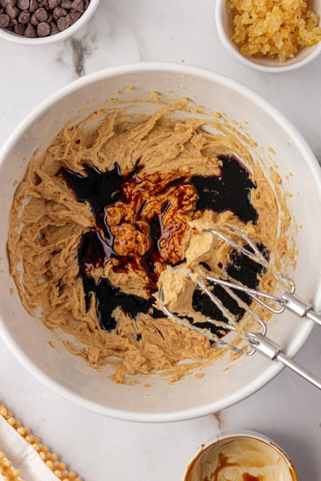 overhead view of molasses and vanilla extract added to cookie dough mixture
