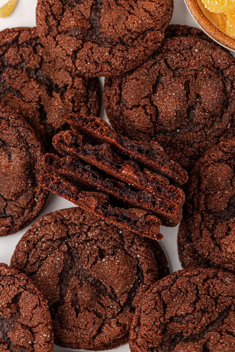 overhead view of two chocolate ginger cookies cut in half surrounded by more cookies