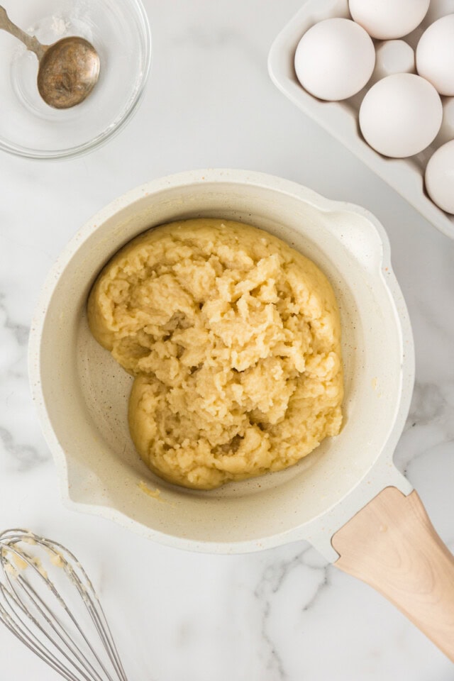 overhead view of butter, water, salt, and flour combined in a saucepan for making choux pastry