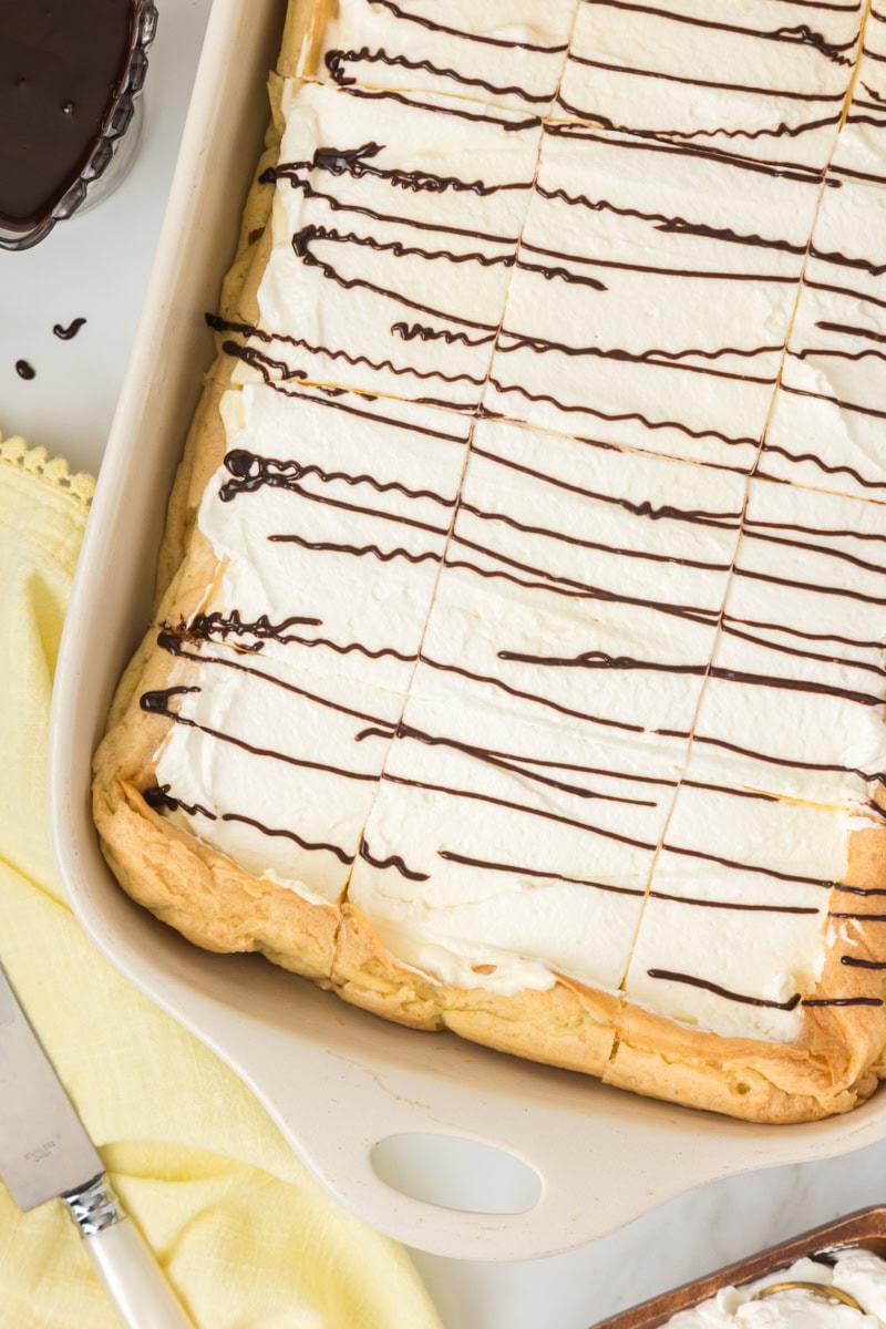 overhead view of cream puff cake cut into squares in a white rectangular pan