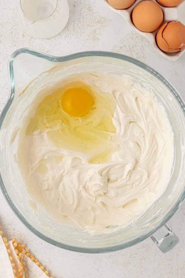 overhead view of egg added to cheesecake mixture