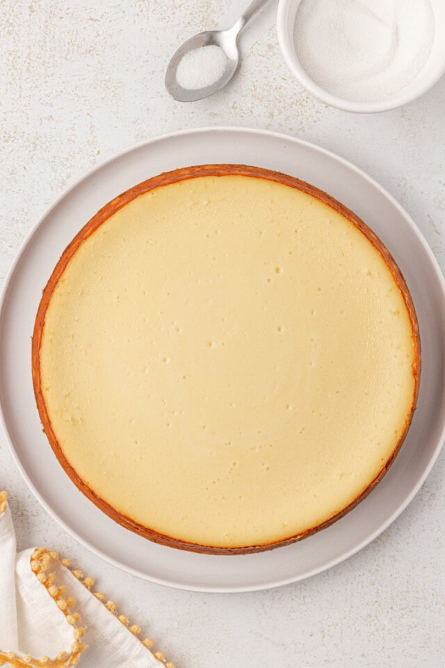 overhead view of freshly baked cheesecake on a white serving plate