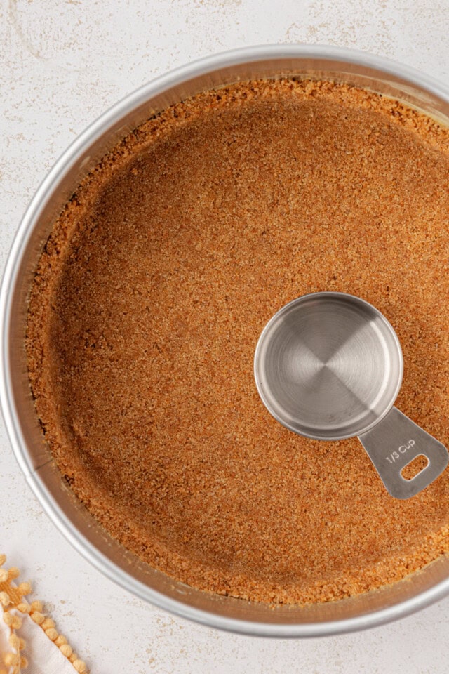 overhead view of graham cracker crust pressed into a springform pan