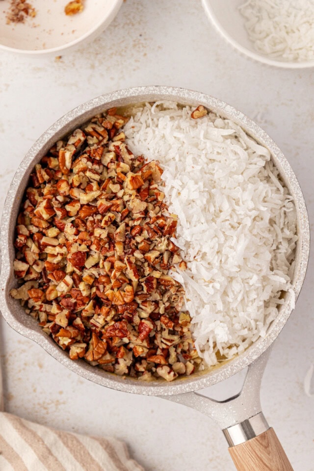 overhead view of coconut, pecans, and vanilla added to cooked frosting mixture