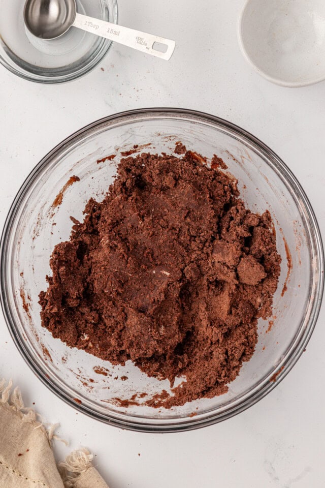 overhead view of chocolate tart dough in a glass mixing bowl