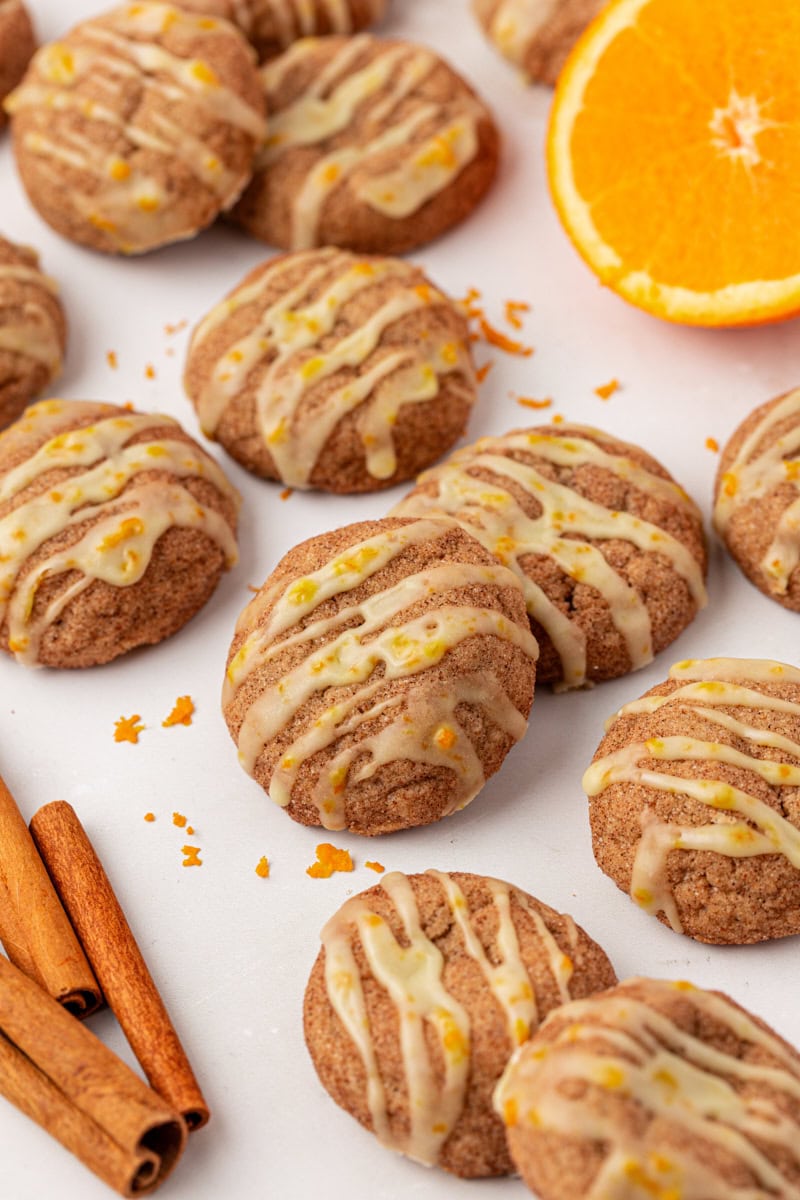 sugar and spice cookies topped with orange glaze, scattered on a white surface