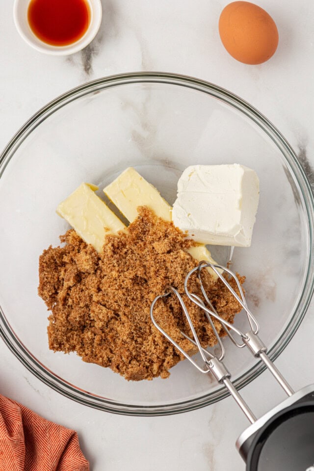 overhead view of butter, cream cheese, and brown sugar in a glass mixing bowl