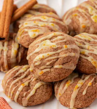 sugar and spice cookies topped with orange glaze on a white plate