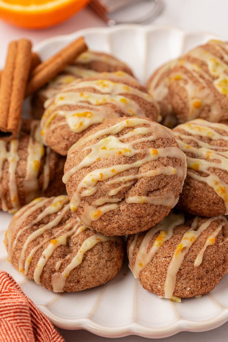 sugar and spice cookies topped with orange glaze on a white plate